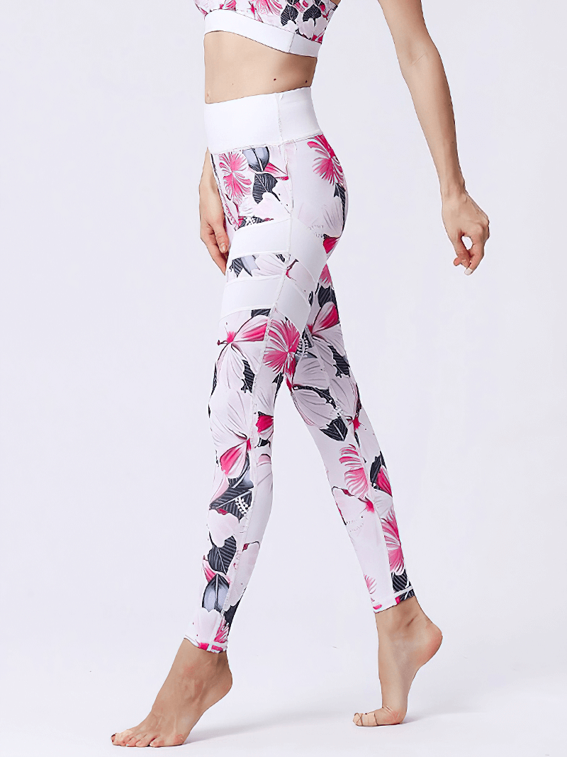Woman wearing high-waist sports leggings with pink flower prints, ideal for yoga and fitness. Nylon-spandex for stretch and comfort.